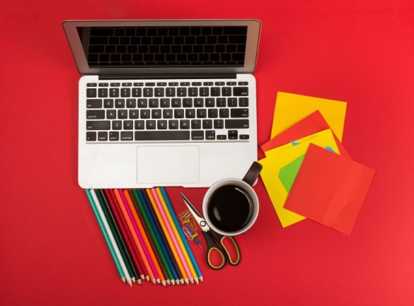 Creative messy workplace with laptop and stationery